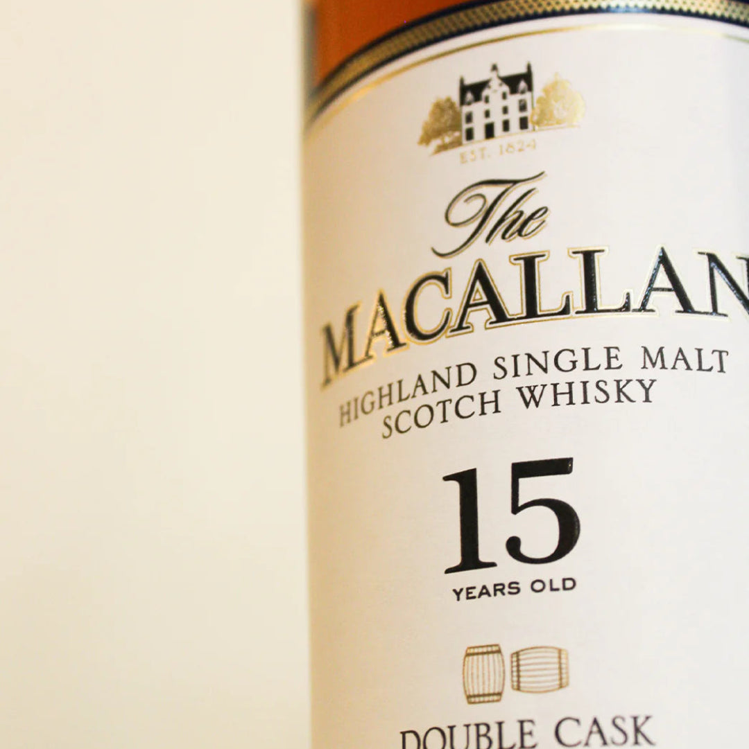 Bottle of Macallan 15 Year Old Double Cask Single Malt Scotch Whisky with box, showcasing premium packaging and golden amber color.
