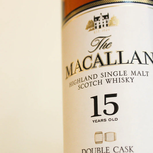 Bottle of Macallan 15 Year Old Double Cask Single Malt Scotch Whisky with box, showcasing premium packaging and golden amber color.